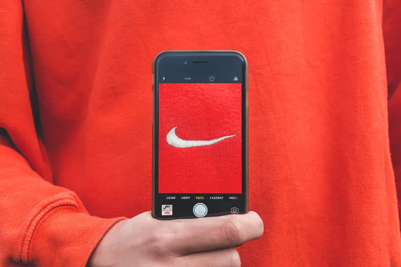 person holding iPhone taking picture on Nike label